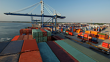 Containers on ship in port with crane in background