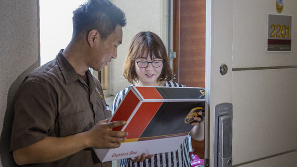 Male UPS driver showing a UPS Express package to a female 