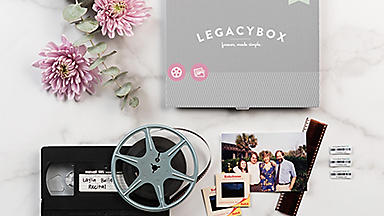 Overhead view of a LegacyBox with flowers, video tapes, pictures, and barcodes