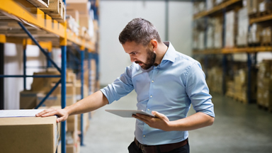 Male in warehouse holding clipboard