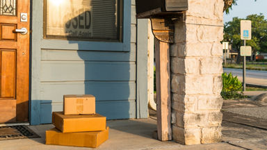 Three packages sitting on the porch of a closed business