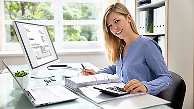 Woman in front of computer with calculator