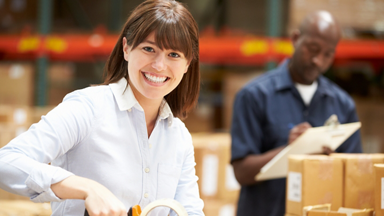 Woman holding tape gun taping a package