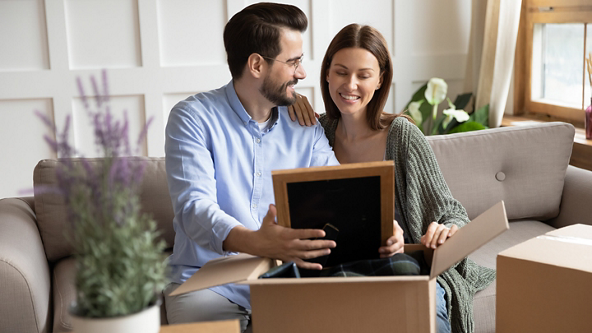 Male and female looking at a picture they pulled from a box
