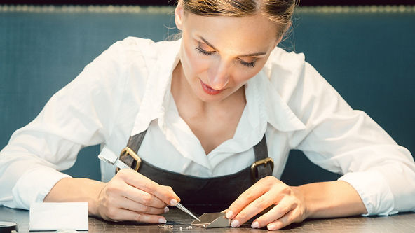 Female jeweler sorting diamonds on the table