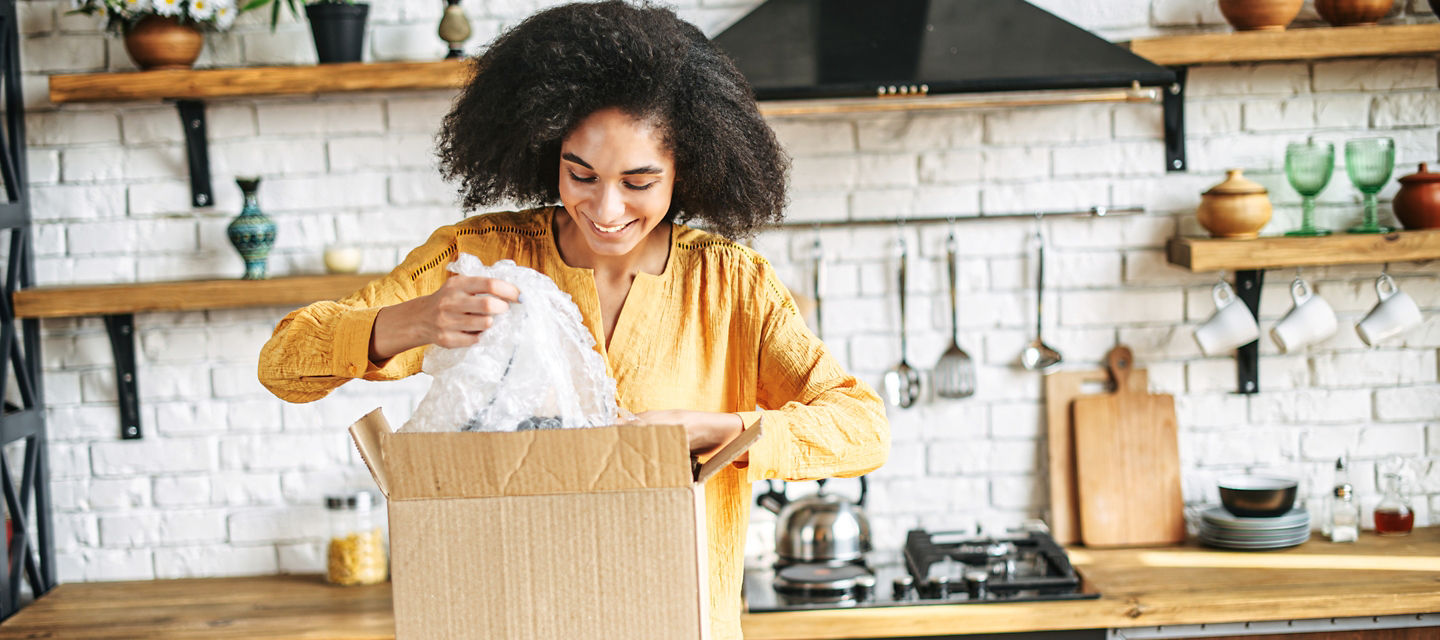 Female opening a box on her kitchen island