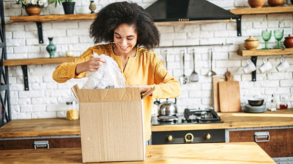 Female pulling bubble wrap from a box in a kitchen