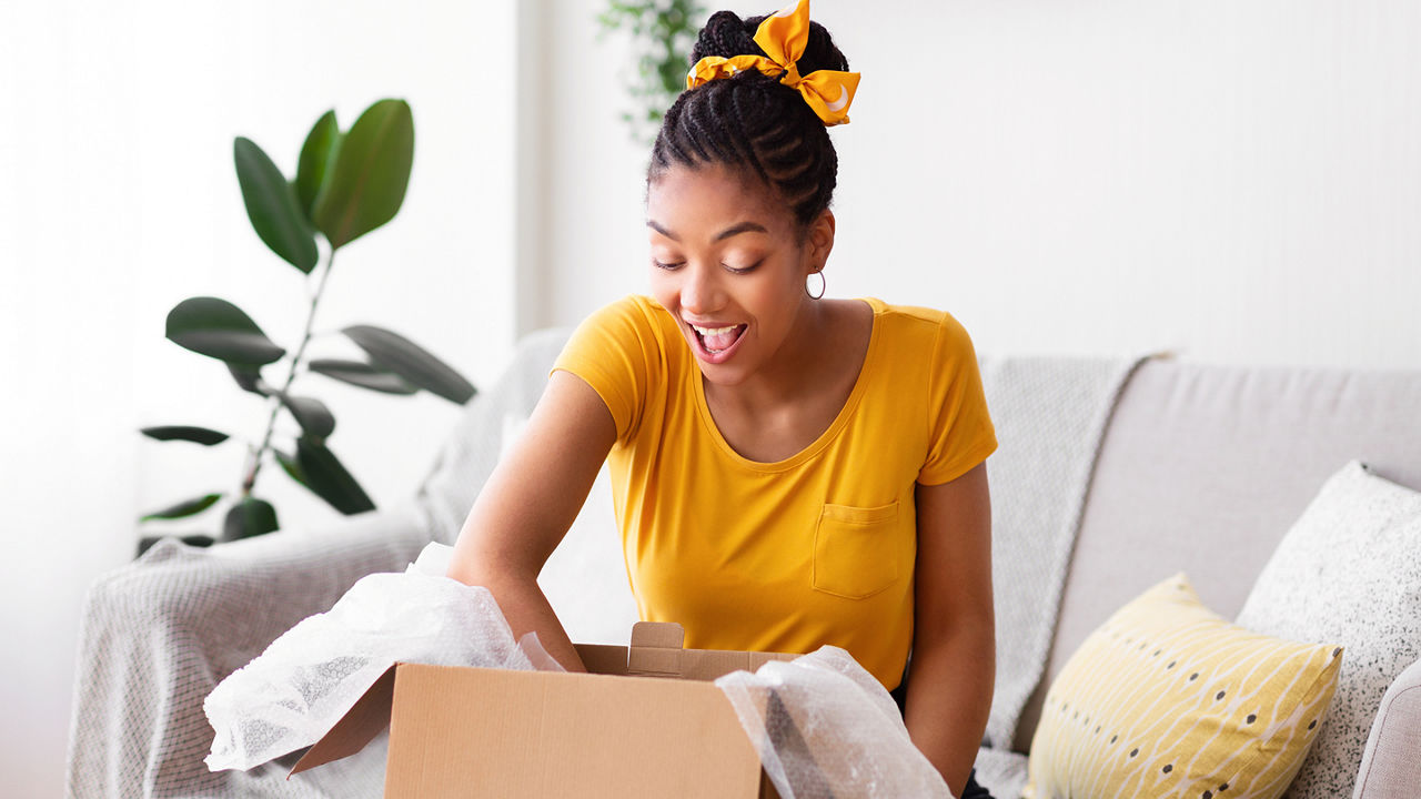 Female sitting on a couch with her hand in an open box
