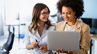 Two women working on a laptop together